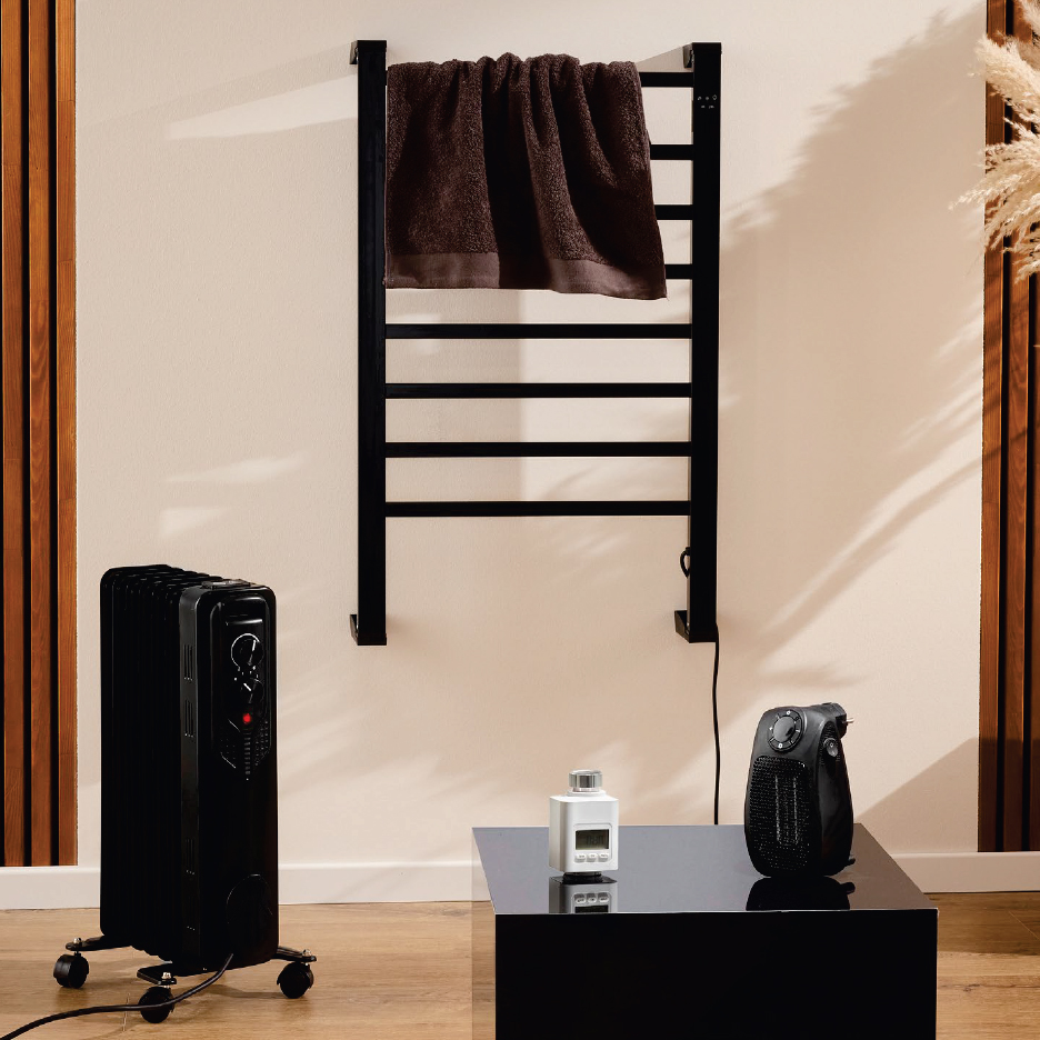 Черни отоплителни уреди: маслен радиатор, сушилник за кърпи и вентилаторен нагревател в стая.