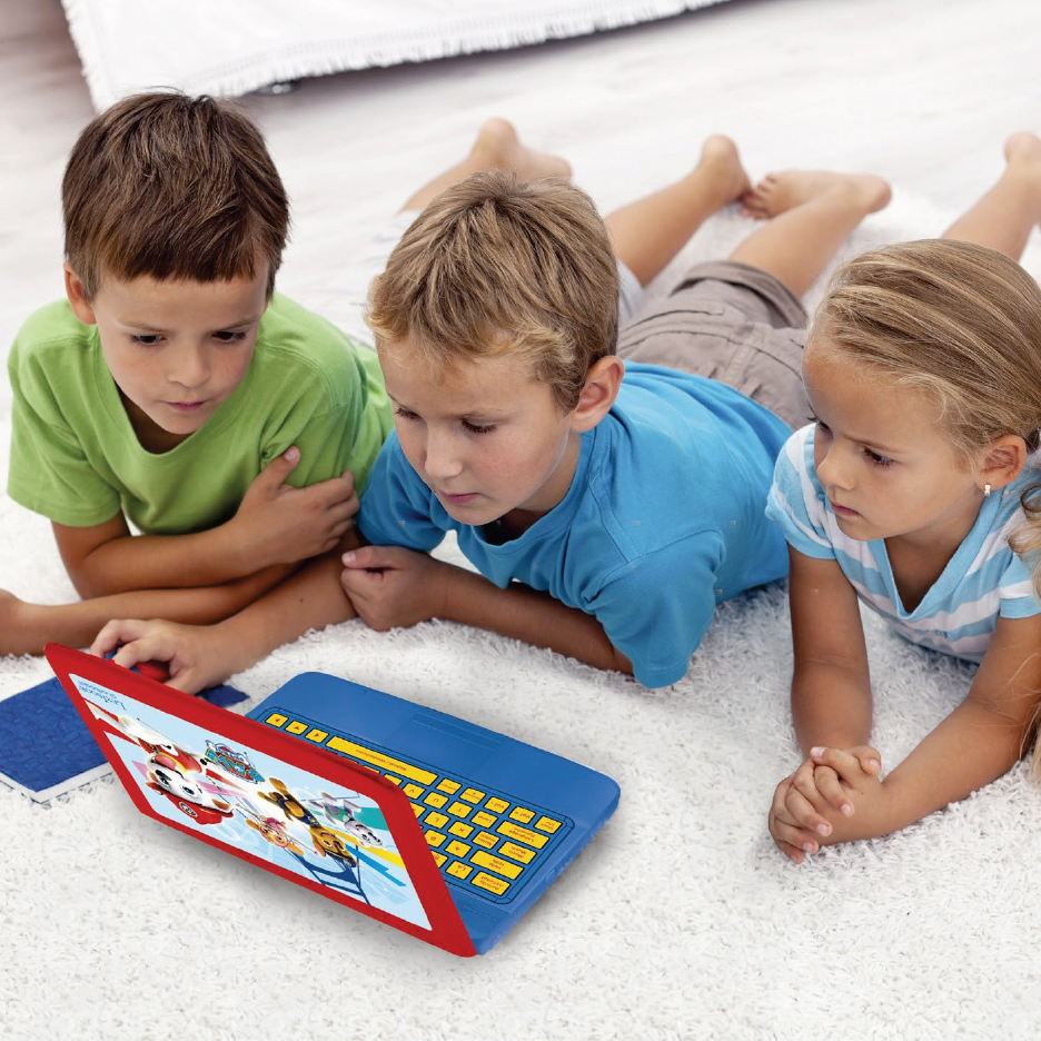 Три деца лежат на килим и гледат детски лаптоп с анимационни герои.