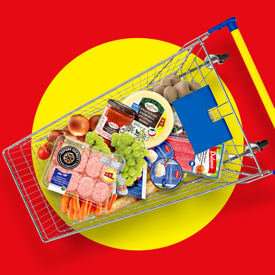 Количка за пазаруване, пълна с хранителни стоки като месо, сирене, зеленчуци и плодове, на червено-жълт фон.