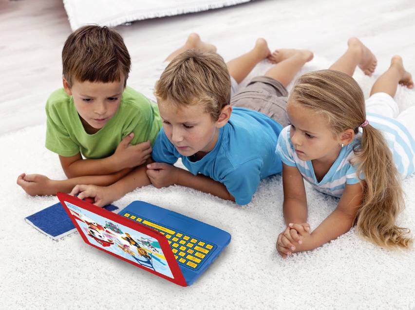 Три деца лежат на килим и гледат в детски лаптоп с анимационни герои.